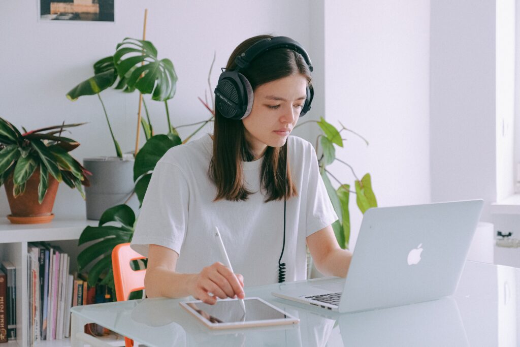Photo of girl with a laptop and headphones participating in e-learning